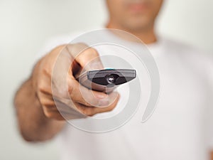 Closeup of a man press the remote controller button on white background