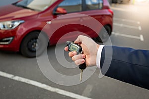 Closeup of man pressing the button on remote car alarm system