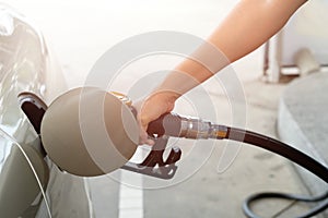 Closeup of man pumping gasoline fuel in car at gas station. Fuel