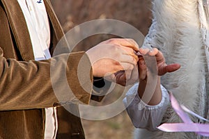 A closeup of a man putting an engagement ring on his girlfriend