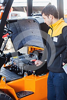 CloseUp man repairs a heavy truck loader