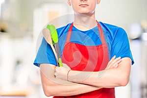 closeup of man`s chest in apron with kitchen