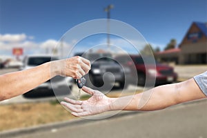 Closeup a man`s hand is delivering a car key to another man`s hand