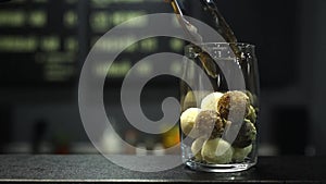 Closeup of man`s hand folds handmade sweets into a glass jar. healthy sweet treats.