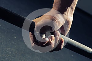 Closeup of man`s hand gripping a barbell photo