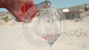 Closeup of the man's hand pouring rose wine into the glass. Stellenbosch, South Africa.