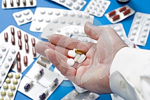 Closeup of a man`s hand with several different pills