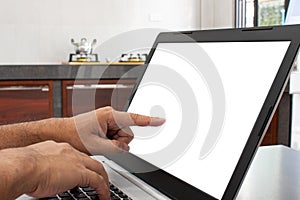 Closeup, A man`s hand is a touch on a laptop blank screen to search out how to cook. notebook computer white screen on the table.