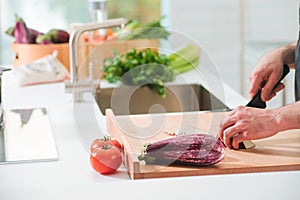 Closeup man's hands cutting vegetables in a kitchen
