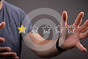 Closeup of the man's hands holding five stars ranking system.