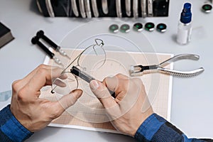 Closeup of man`s hands repairing glasses