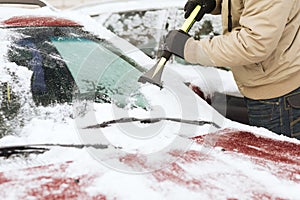 Closeup of man scraping ice from car