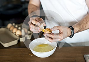 Closeup of man separating egg yolk photo