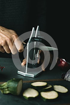 closeup of a man sharpening a kitchen knife