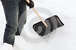 Closeup of man shoveling snow from driveway