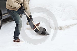 Closeup of man shoveling snow from driveway