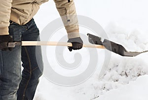 Closeup of man shoveling snow from driveway