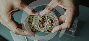 shredding a cannabis bud with a grinder, banner photo
