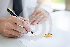 Closeup of a man Signing Contract or premarital agreement, filling petition form agreement of divorce in office at lawyer desk in