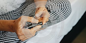 man pricking his finger with a fingerstick, banner format photo