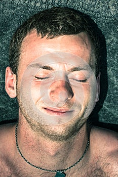 Closeup of man sleeping on towel