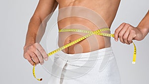 Closeup of man standing wrapped in towel at white studio