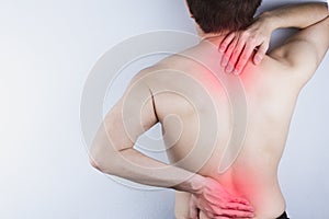 Closeup man suffering from lower back and neck pain with red spot. Health care and medical concept