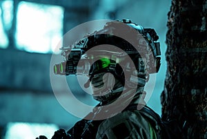 Closeup man uniform with machine gun and turned on night vision device. Airsoft soldier with green light on face in night building