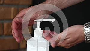 Closeup of man using hand sanitizer dispenser disinfecting with gel. used for hygiene and keeping hands clean to prevent