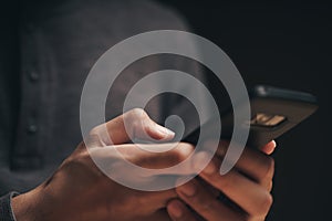 Closeup of a man using a smartphone on the wooden table, searching, browsing, social media, message, email, internet digital