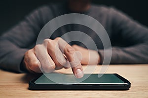 Closeup of a man using a smartphone on the wooden table, searching, browsing, social media, message, email, internet digital