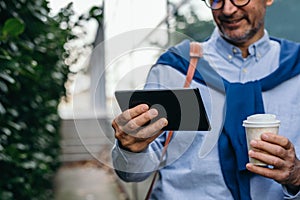 Closeup man using tablet outdoor in the city