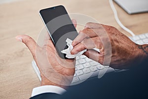 Closeup of man wipe his phone with a tissue to prevent germs, bacteria or dirt in his office. Technology, hands and male