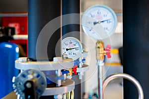 Closeup of manometer, measuring gas pressure. Pipes and valves at industrial plant. Pressure gauge, measuring instrument close up