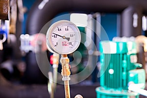 Closeup of manometer, measuring gas pressure. Pipes and valves at industrial plant. Pressure gauge, measuring instrument close up