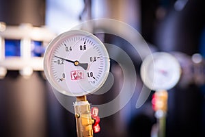 Closeup of manometer, measuring gas pressure. Pipes and valves at industrial plant. Pressure gauge, measuring instrument close up