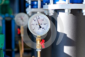 Closeup of manometer, measuring gas pressure. Pipes and valves at industrial plant. Pressure gauge, measuring instrument close up