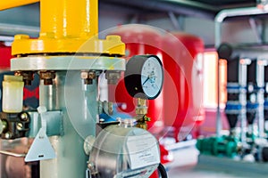 Closeup of manometer, pipes and faucet valves of heating system in a boiler room