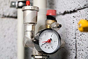 Closeup of manometer, pipes and faucet valves of heating system in a boiler room at home