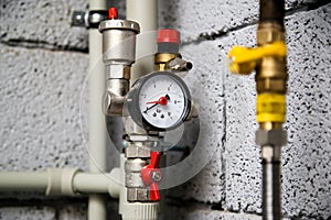 Closeup of manometer, pipes and faucet valves of heating system in a boiler room at home