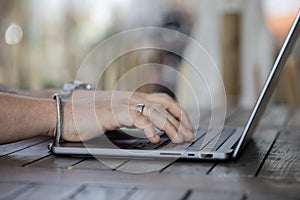 Closeup of a mans hand working on a laptop