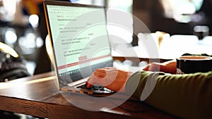 Closeup mans hands freelancer sitting in cafe working laptop