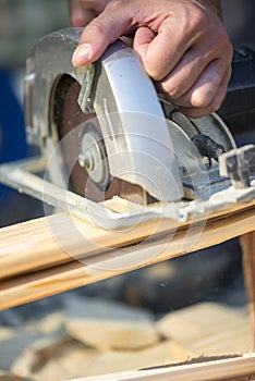 Closeup of manual worker using circular saw