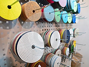 Closeup many different polishing and grinding replaceable disks for industrial power tools hanging on stand at hardware equipment