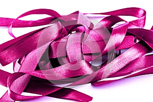 Mauve tangled satin ribbons on white.