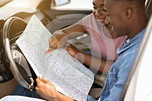 Closeup of map in african american couple hands, car trip