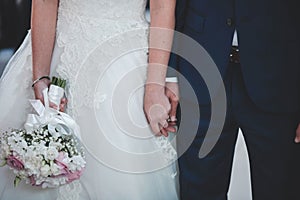 Closeup of a marrying couple holding hands during the wedding ceremony