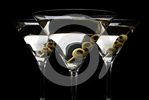 Closeup Martini drinks with olives on stick isolated on black