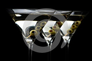 Closeup Martini drinks with stick with olives on black