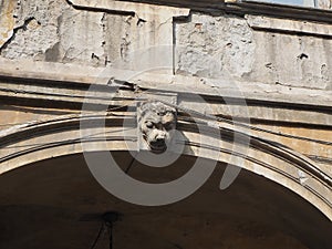 Closeup of masks of stone on arches worn by time